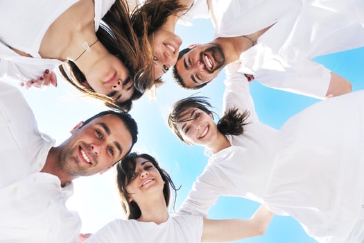 Group of happy young people in circle at beach photo