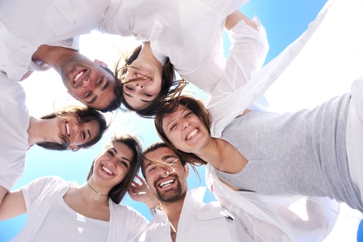 Group of happy young people in circle at beach photo