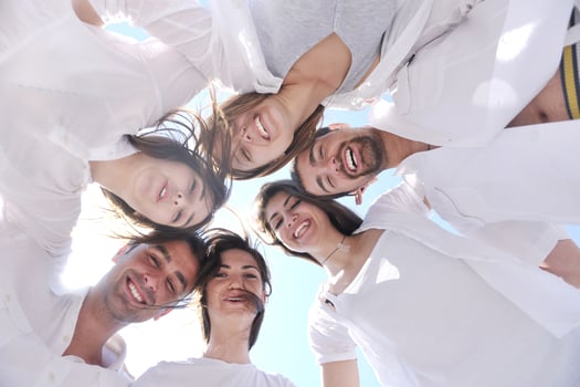 Group of happy young people in circle at beach photo