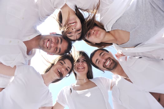 Group of happy young people in circle at beach photo