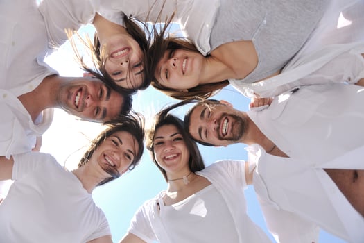 Group of happy young people in circle at beach photo