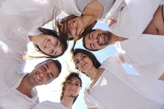 Group of happy young people in circle at beach photo