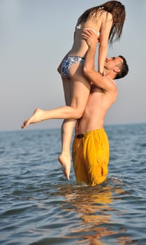 happy young couple have fun on beach photo
