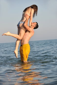 happy young couple have fun on beach photo