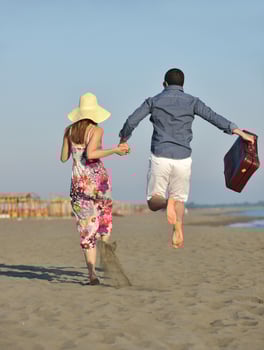 couple on beach with travel bag photo