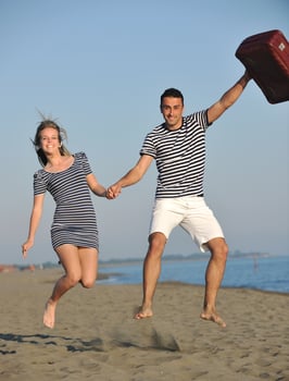 couple on beach with travel bag photo