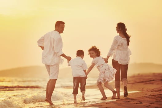 happy young family have fun on beach at sunset photo