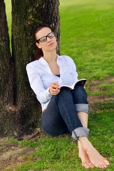 Young woman reading a book in the park photo