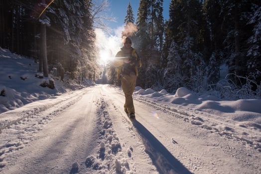 young photographer walking on snowy country road photo