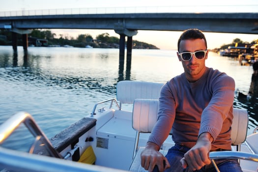 portrait of happy young man on boat photo