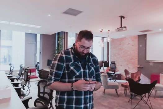 Office manager work in coworking space using smartphone analyzing online market trends, focused man worker reading financial news or browsing internet on phone. Technology concept photo
