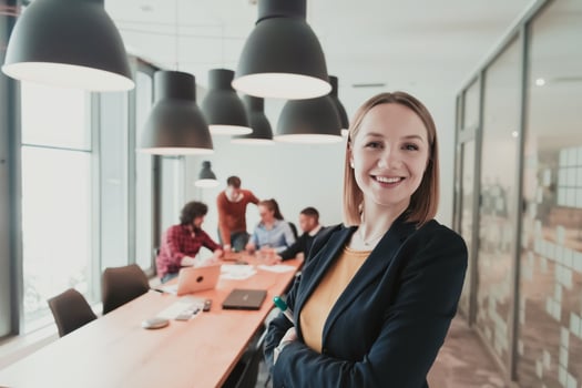 Portrait of happy businesswoman owner in modern office. Businesswoman smiling and looking at camera. Busy diverse team working in background. Leadership concept. Head shot. photo