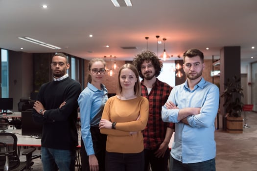 Portrait of successful creative business team looking at camera and smiling. Diverse business people standing together at startup. Selective focus photo