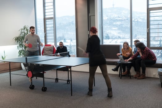 Young start up business man and woman playing table tennis at modern creative office space people group have meeting and brainstorming in background photo