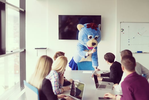 boss dresed as bear having fun with business people in trendy office photo