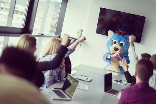 boss dresed as bear having fun with business people in trendy office photo