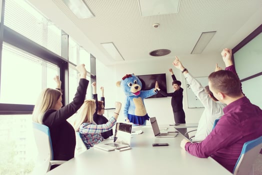 boss dresed as bear having fun with business people in trendy office photo