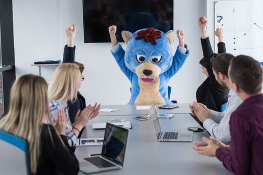 boss dresed as bear having fun with business people in trendy office photo