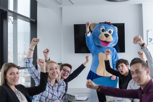 boss dresed as bear having fun with business people in trendy office photo