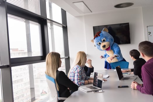 boss dresed as bear having fun with business people in trendy office photo
