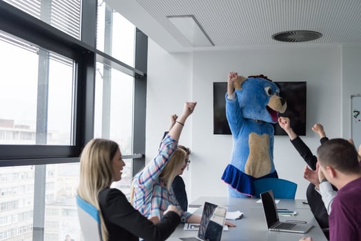boss dresed as bear having fun with business people in trendy office photo
