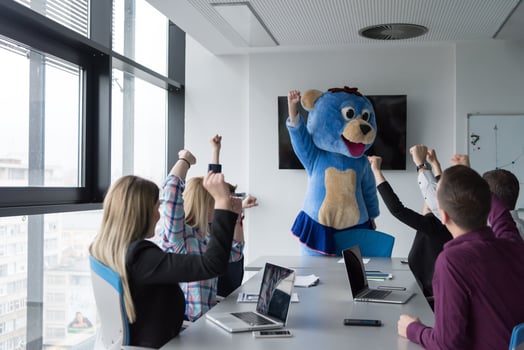 boss dresed as bear having fun with business people in trendy office photo