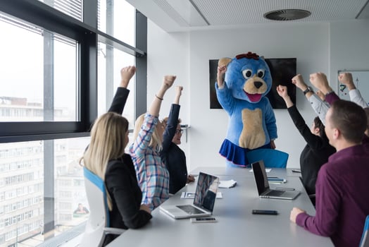 boss dresed as bear having fun with business people in trendy office photo