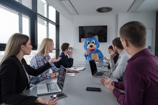 boss dresed as bear having fun with business people in trendy office photo