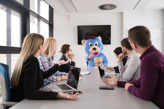 boss dresed as bear having fun with business people in trendy office photo