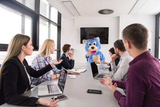 boss dresed as bear having fun with business people in trendy office photo