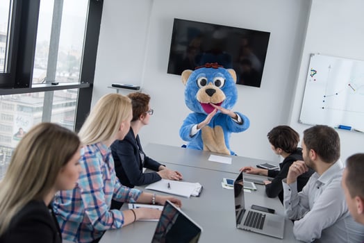 boss dresed as bear having fun with business people in trendy office photo