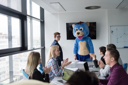 boss dresed as bear having fun with business people in trendy office photo