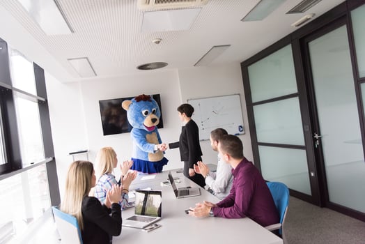 boss dresed as bear having fun with business people in trendy office photo