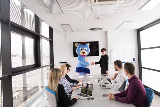 boss dresed as bear having fun with business people in trendy office photo