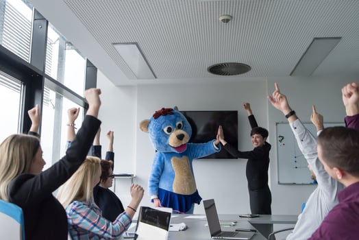 boss dresed as bear having fun with business people in trendy office photo