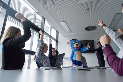 boss dresed as bear having fun with business people in trendy office photo