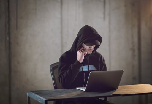 talented hacker using laptop computer while working in dark office photo