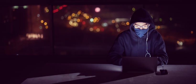hacker using laptop computer while working in dark office photo