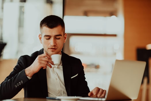 Happy business man sitting at cafeteria with laptop and smartphone. photo