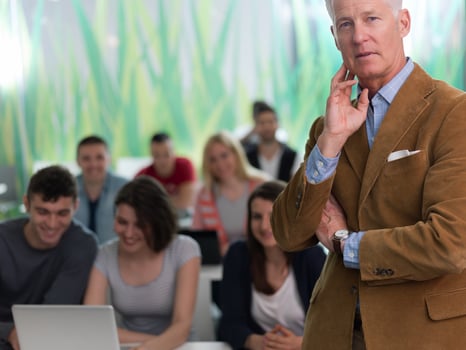 portrait of in teacher in classroom with students group in background photo