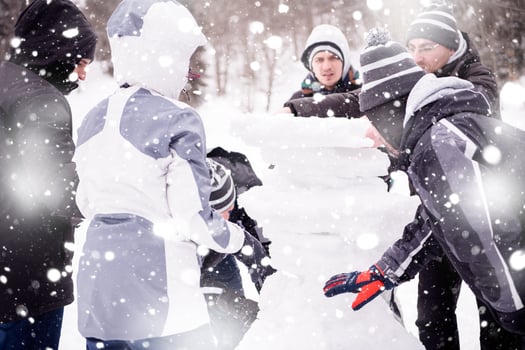 group of young people making a snowman photo
