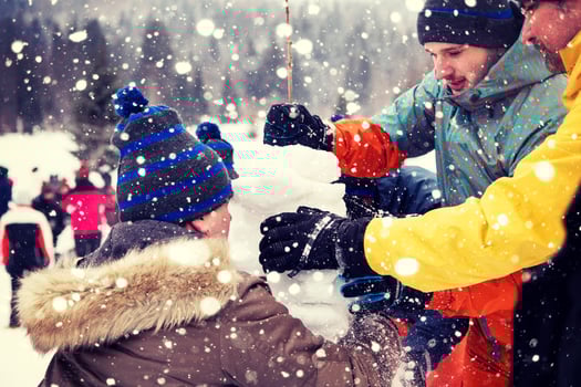 group of young people making a snowman photo