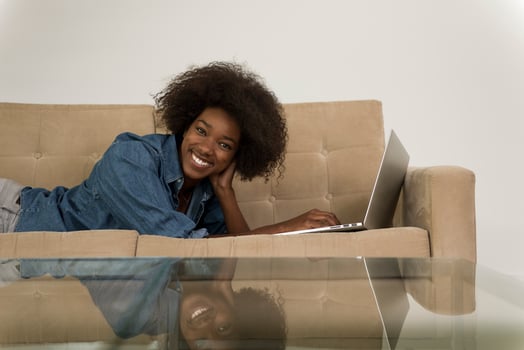 African American woman using laptop on sofa photo