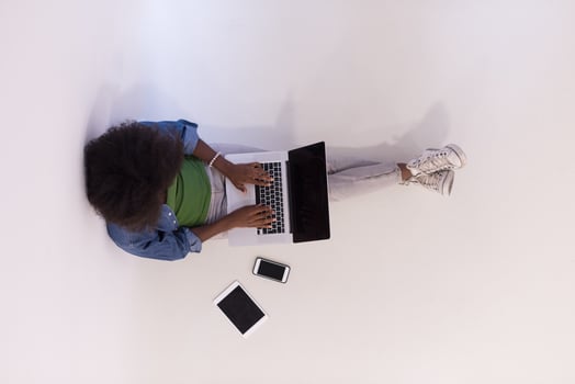 african american woman sitting on floor with laptop top view photo