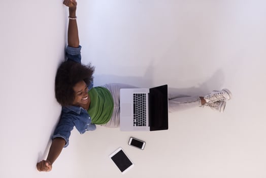 african american woman sitting on floor with laptop top view photo