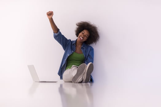 african american woman sitting on floor with laptop photo