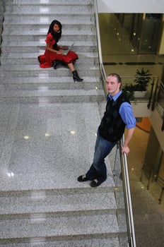 young business man standing on stairs and hold laptop photo