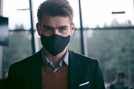business man wearing protective face mask at luxury office photo