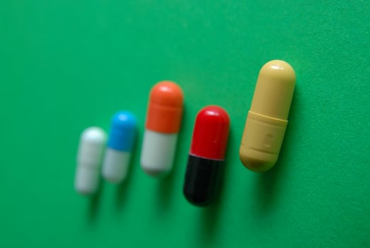 pills on green background in row photo
