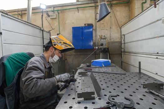 Metal industry worker working in factory, wearing protective face mask during coronavirus or covid19 pandemic. photo
